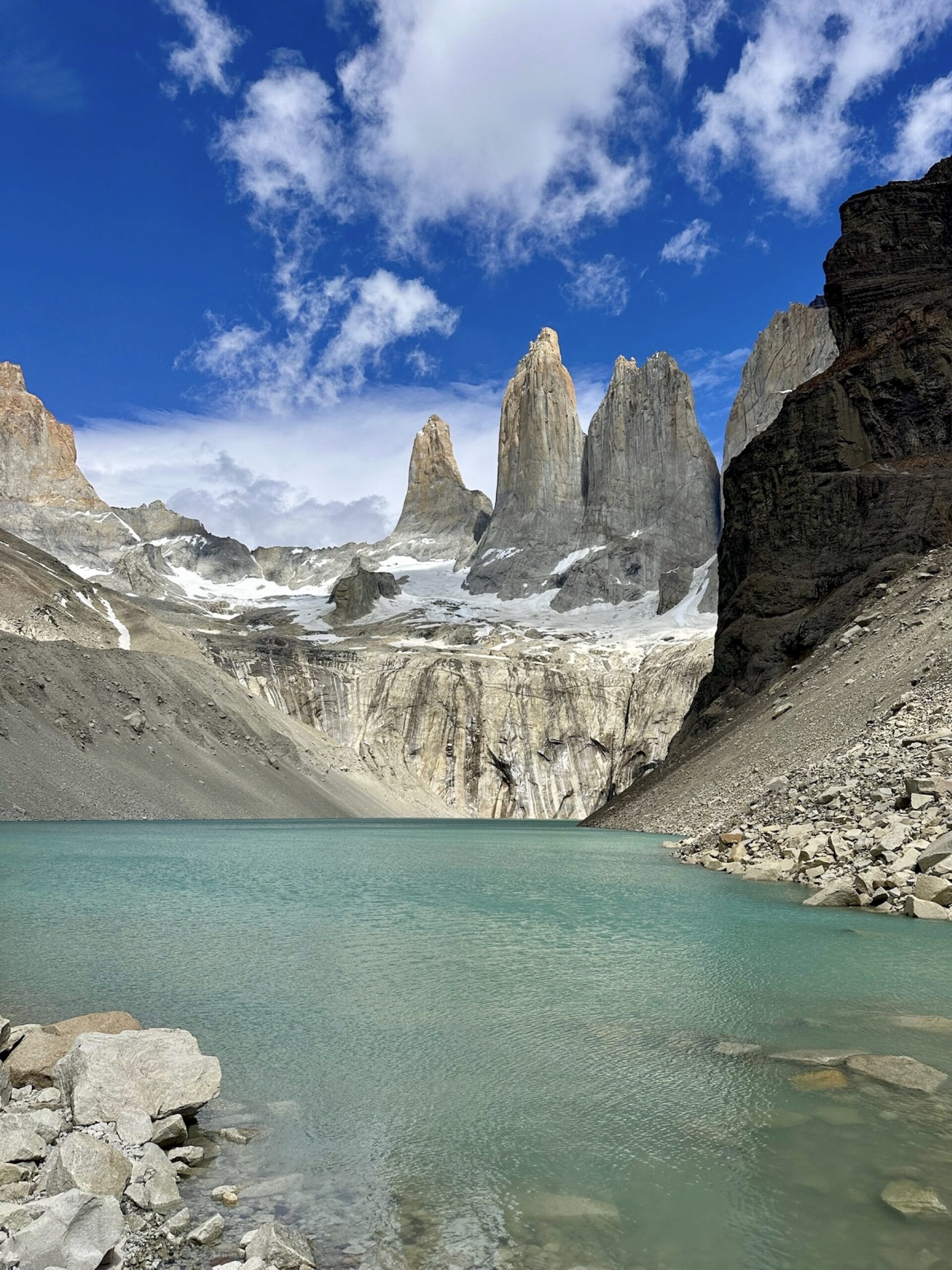 Three Torres del Paine granite towers above a turquoise glacial lagoon
